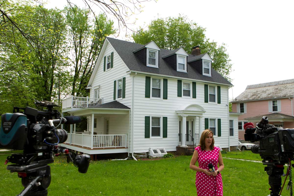TV crews report from outside the house of Baltimore Mayor Catherine Pugh in Baltimore, Md., Thursday, April 25, 2019. Agents with the FBI and IRS are gathering evidence inside the two homes of Pugh and also in city hall.