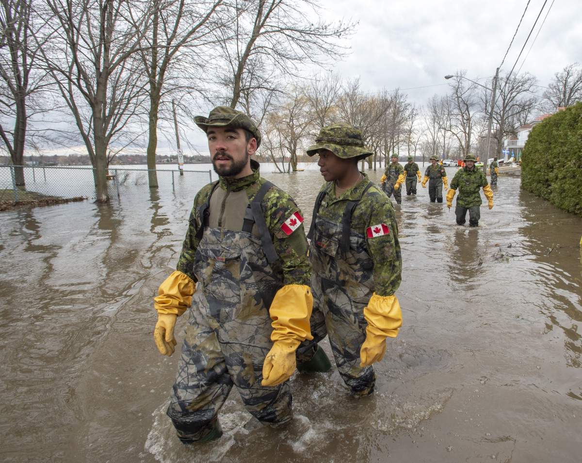 Canadian Forces personnel wade through the floodwaters Thursday, April 25, 2019 in Laval, Que.