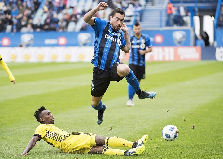 In this file photo, the Montreal Impact's Daniel Lovitz leaps over a challenge by Columbus Crew SC's Harrison Afful. 