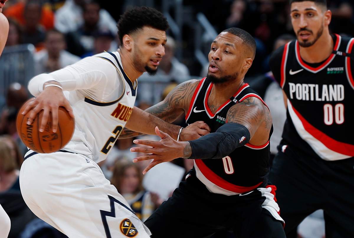 Denver Nuggets guard Jamal Murray, left, looks to pass the ball as Portland Trail Blazers guard Damian Lillard defends in the second half of Game 1 of an NBA basketball second-round playoff series, Monday, April 29, 2019, in Denver. The Nuggets won 121-113. (AP Photo/David Zalubowski)