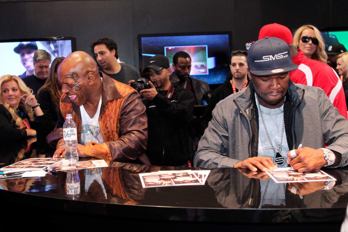 (L-R) Mike Tyson and Curtis ’50 Cent’ Jackson sign autographs at the SMS booth at the Las Vegas Convention Center, in Las Vegas, Nev., on Jan. 9, 2012.