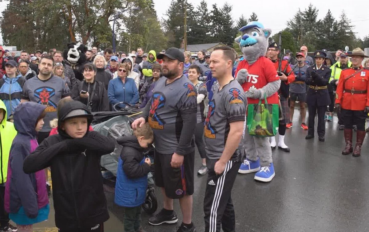 Const. Sarah Becketts widower Brad Aschenbrenner, centre, stands with hundreds of people awaiting the start of the first annual Sarah Beckett Memorial Run in Langford Saturday, April 13.