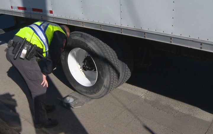 Police check a truck’s weight on Monday before it crosses Calgary’s 9 Avenue S.E. bridge.