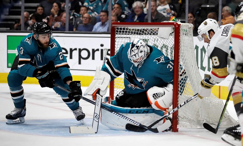 San Jose Sharks' Barclay Goodrow, left, and Martin Jones, center, defend on a shot from Vegas Golden Knights' William Carrier, right, during the second period of Game 5 of an NHL hockey first-round playoff series Thursday, April 18, 2019, in San Jose, Calif. (AP Photo/Ben Margot).