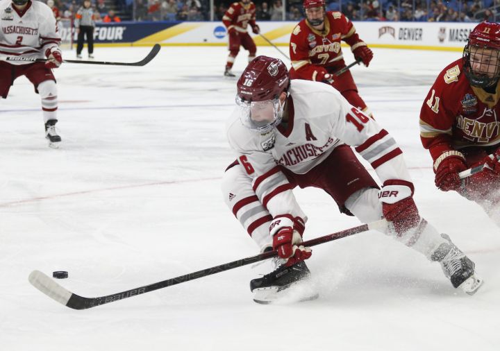 Massachusetts defenceman Cale Makar (16) controls the puck during the second period in a semifinal against Denver during the Frozen Four NCAA men's college hockey tournament Thursday, April 11, 2019, in Buffalo, N.Y. 
