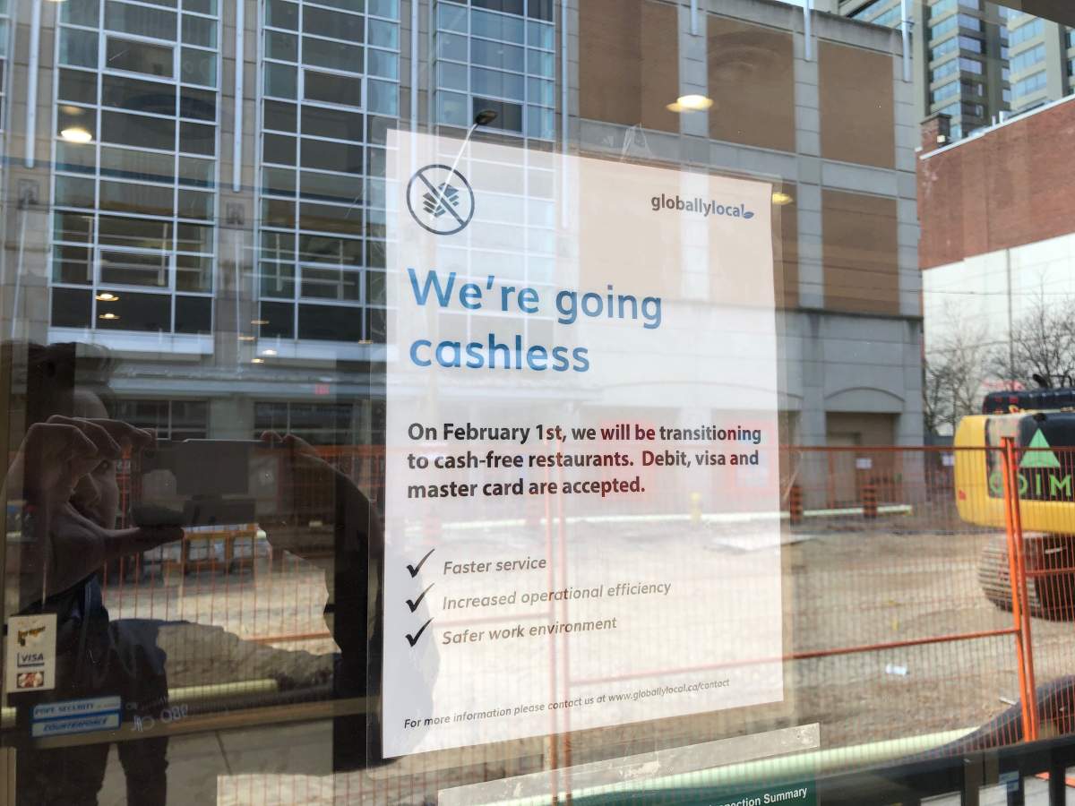 A sign posted on the door of Globally Local’s downtown location that encourages customers to make cashless payments.