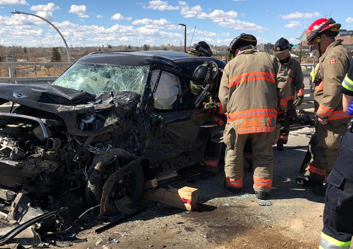 Members of the Saskatoon Fire Department extract the driver from a crashed Mini Cooper on the Traffic Bridge.