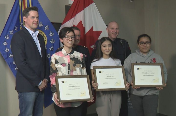 Caroline Mancenido, Jessica Tran and Melissa Segura Gomez are recognized for their leadership in the SADD campaign at Calgary Police Service Headquarters – Westwinds on Wednesday. (Back row, from left: Arthur Lee from SADD, Acting Chief Ray Robitaille and Const. Sean Bunes).