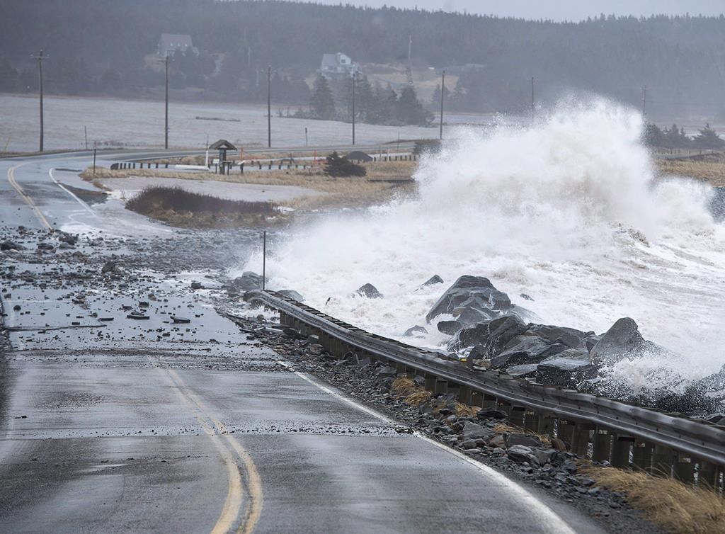 Waves pound the shore on a closed section of Highway 207 in Lawrencetown, N.S. on Friday, Jan. 5, 2018.