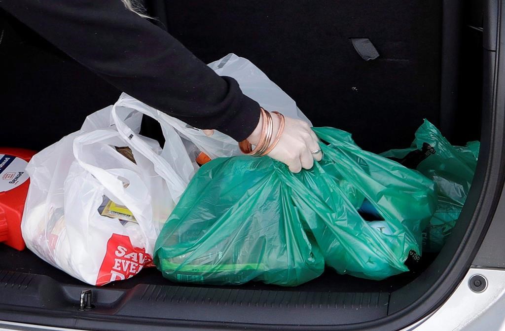 A shopper places her goods into her car outside a supermarket in Christchurch, New Zealand, Friday, Aug. 10, 2018. Newfoundland and Labrador has announced it will become the second province to ban plastic bags.