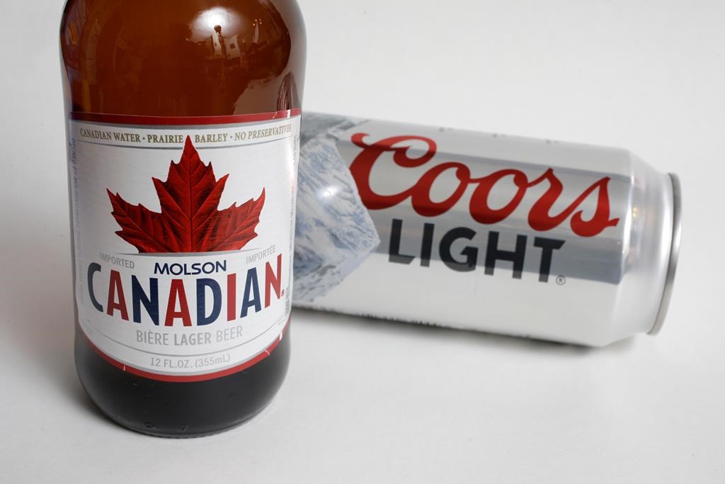 In this Feb. 14, 2018, file photo, Molson Coors products Molson Canadian beer, left, and Coors Light beer are shown in Walpole, Mass. THE CANADIAN PRESS/AP Photo/Steven Senne, File.
