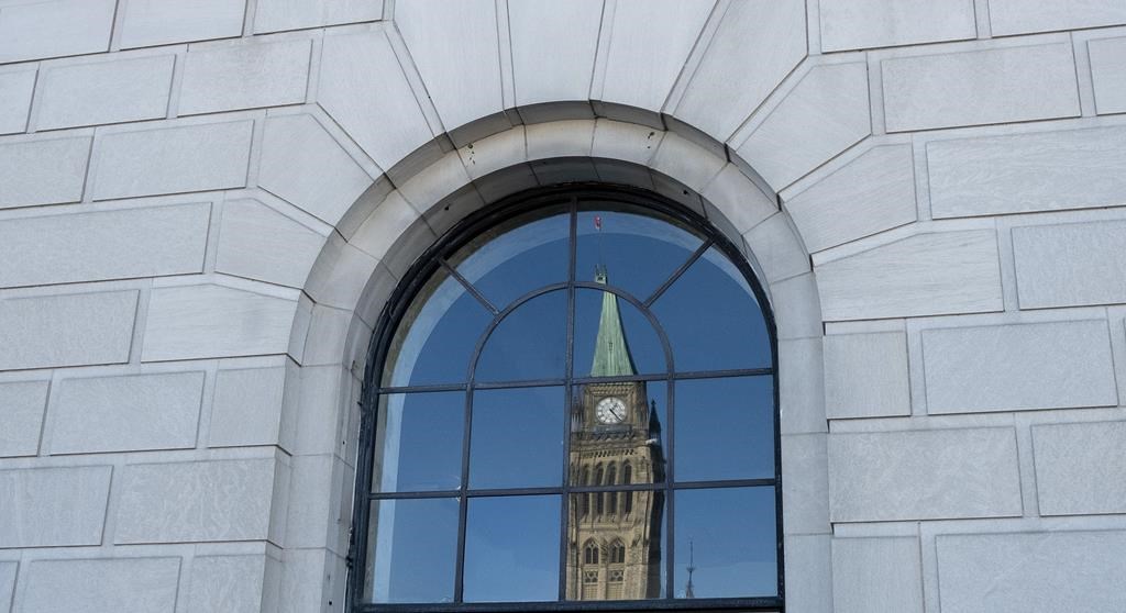 The Peace tower is reflected in a window in Ottawa, Tuesday March 26, 2019.