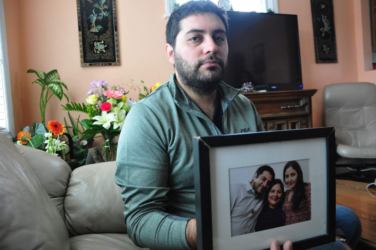 Oliver Antonio Munoz Orellana holds a picture of himself with his mother Tamara Orellana Azolas, centre, and his sister.
