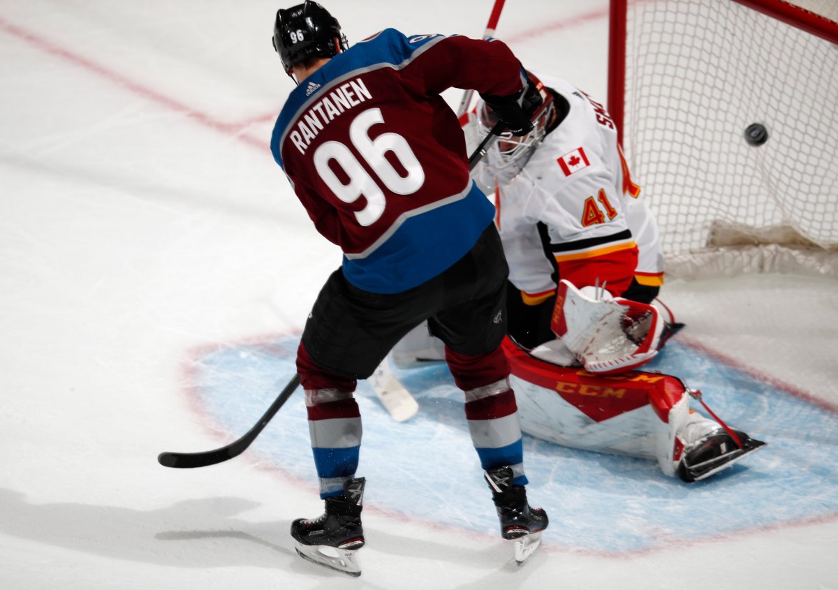 Colorado Avalanche right wing Mikko Rantanen, left, scores a goal past Calgary Flames goaltender Mike Smith to tie the score in the third period of Game 4 of an NHL hockey playoff series Wednesday, April 17, 2019, in Denver. The Avalanche won 3-2 in overtime. (AP Photo/David Zalubowski).