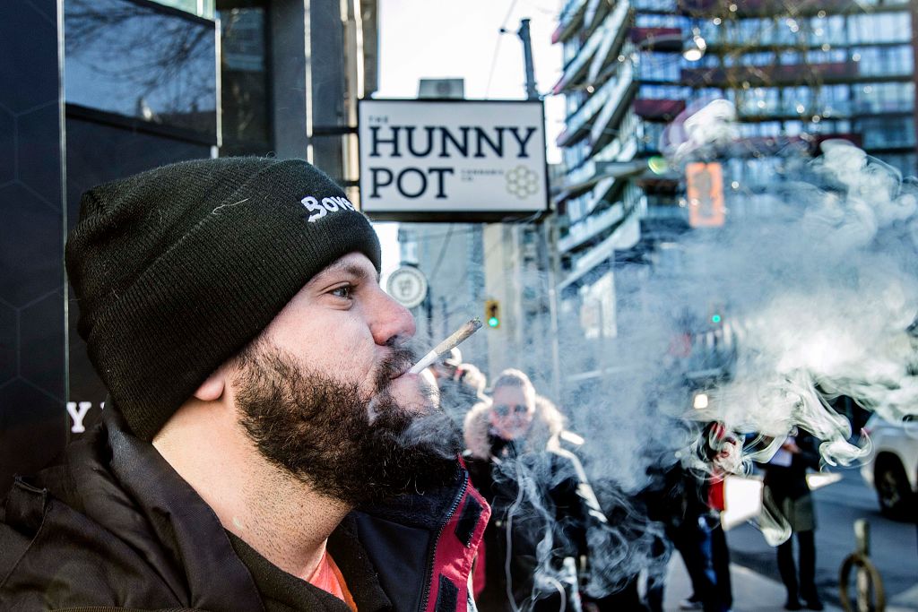 Cannabis educator Jonathan Hirsh smokes a joint he purchased outside the Hunny Pot Cannabis Co. store in Toronto. 