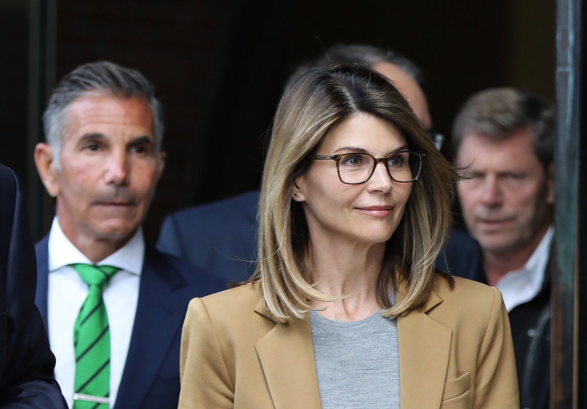 Actress Lori Loughlin and her husband Mossimo Giannulli, wearing green tie at left, leave the John Joseph Moakley United States Courthouse in Boston on April 3, 2019. 