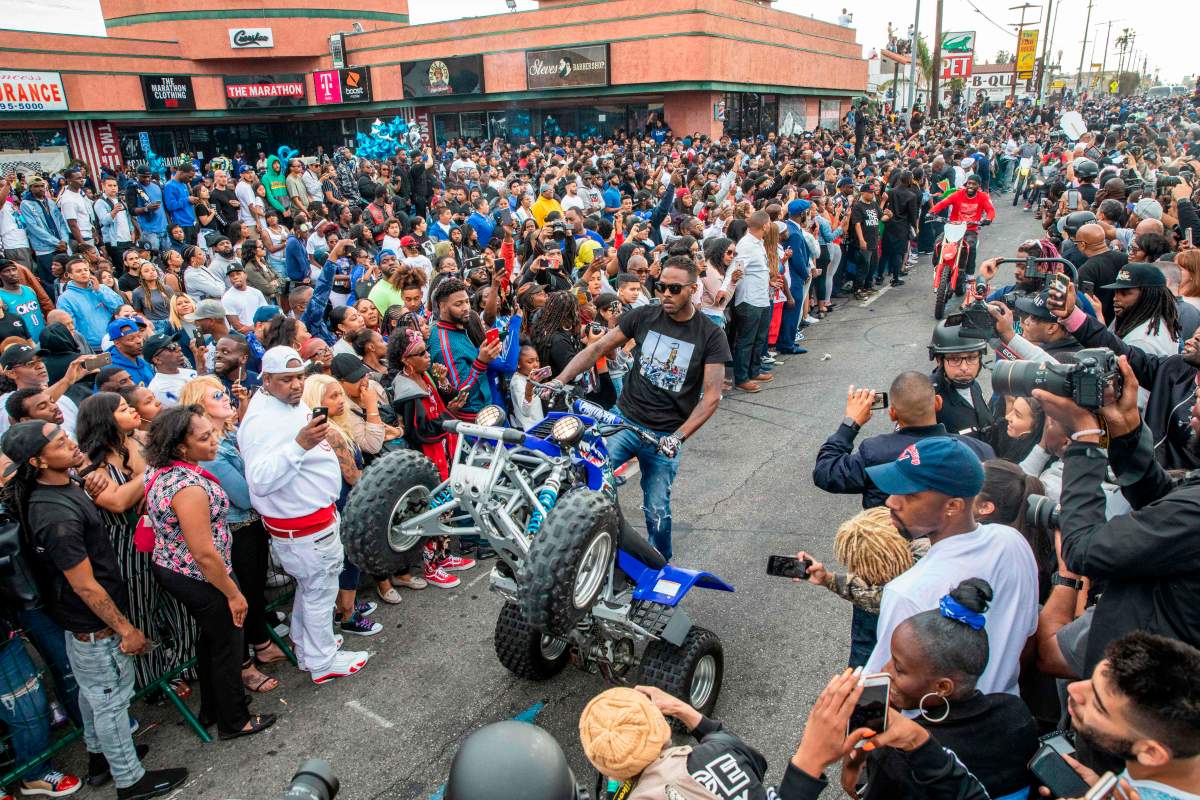 The procession for Nipsey Hussle passes his Marathon Clothing store after his memorial at the Staples Center in Los Angeles, California, on April 11, 2019. (KYLE GRILLOT/AFP/Getty Images)