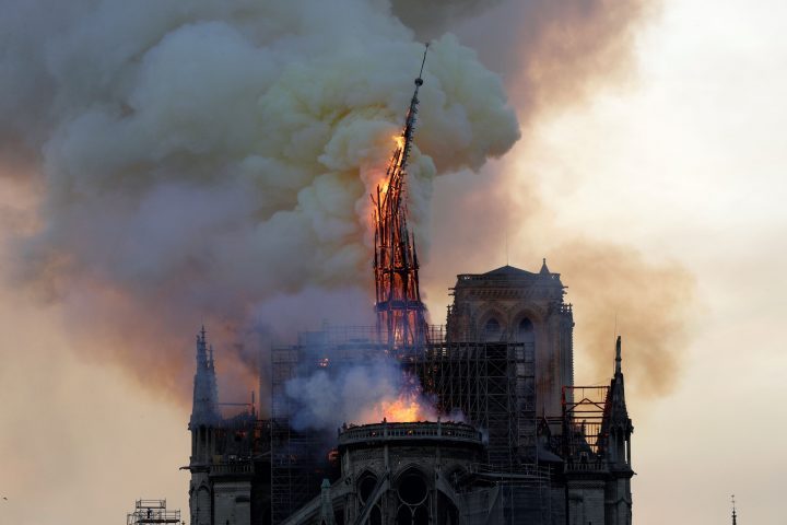 The steeple of the landmark Notre-Dame Cathedral collapses as the cathedral is engulfed in flames in central Paris on April 15, 2019.