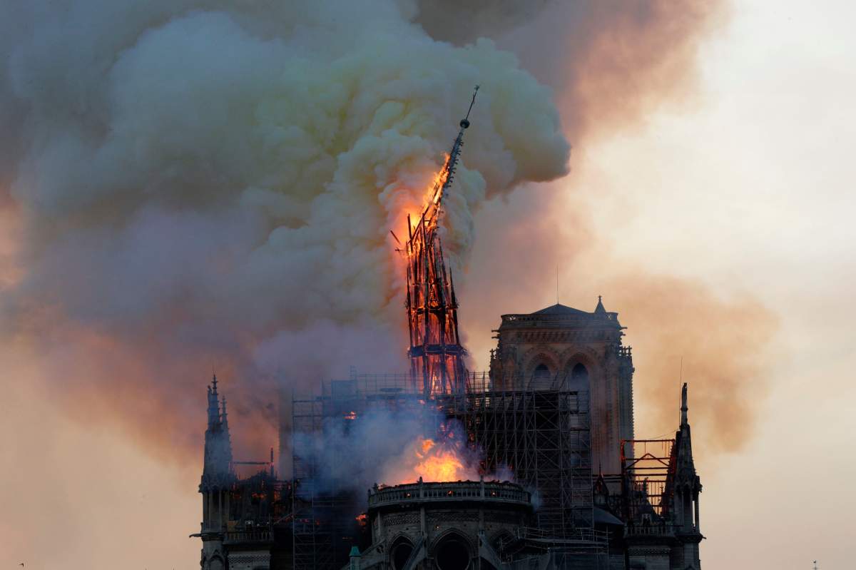 The steeple, engulfed in flames, collapses as the roof of the Notre-Dame de Paris Cathedral burns on April 15, 2019 in Paris.