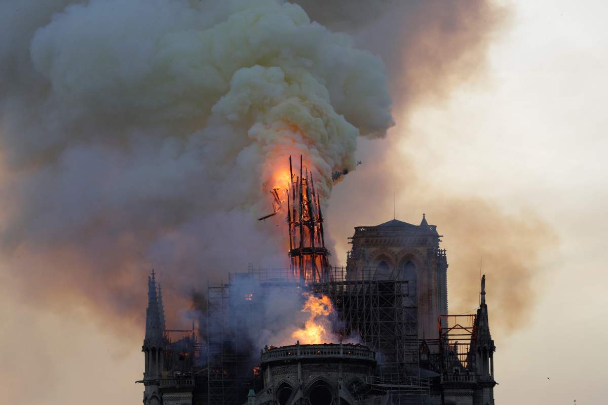 The spire engulfed in flames collapses as the roof of the Notre-Dame de Paris Cathedral burns on April 15, 2019 in Paris.