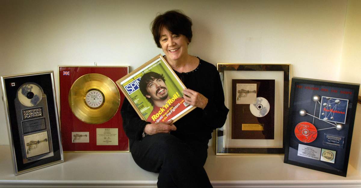Virginia Hanlon Grohl, mother of Dave Grohl, holds a framed cover of a 1997 Spin magazine with a picture of her son and other various awards earned by the Foo Fighters.