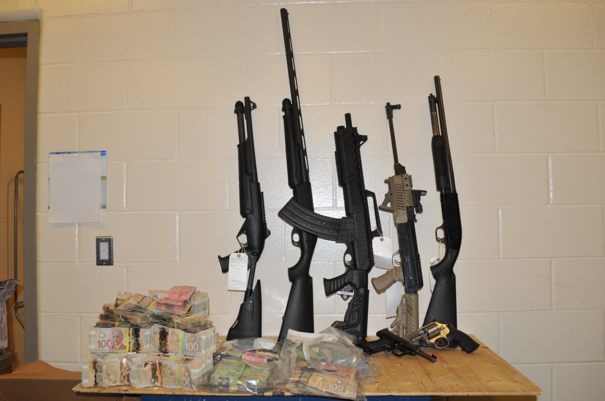Guns and cash seized during the execution of a search warrant in Prince George last week. 