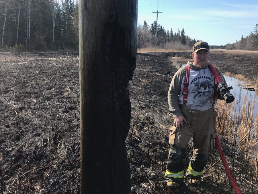 A worker next to a burned Dauphin-area Hydro pole.