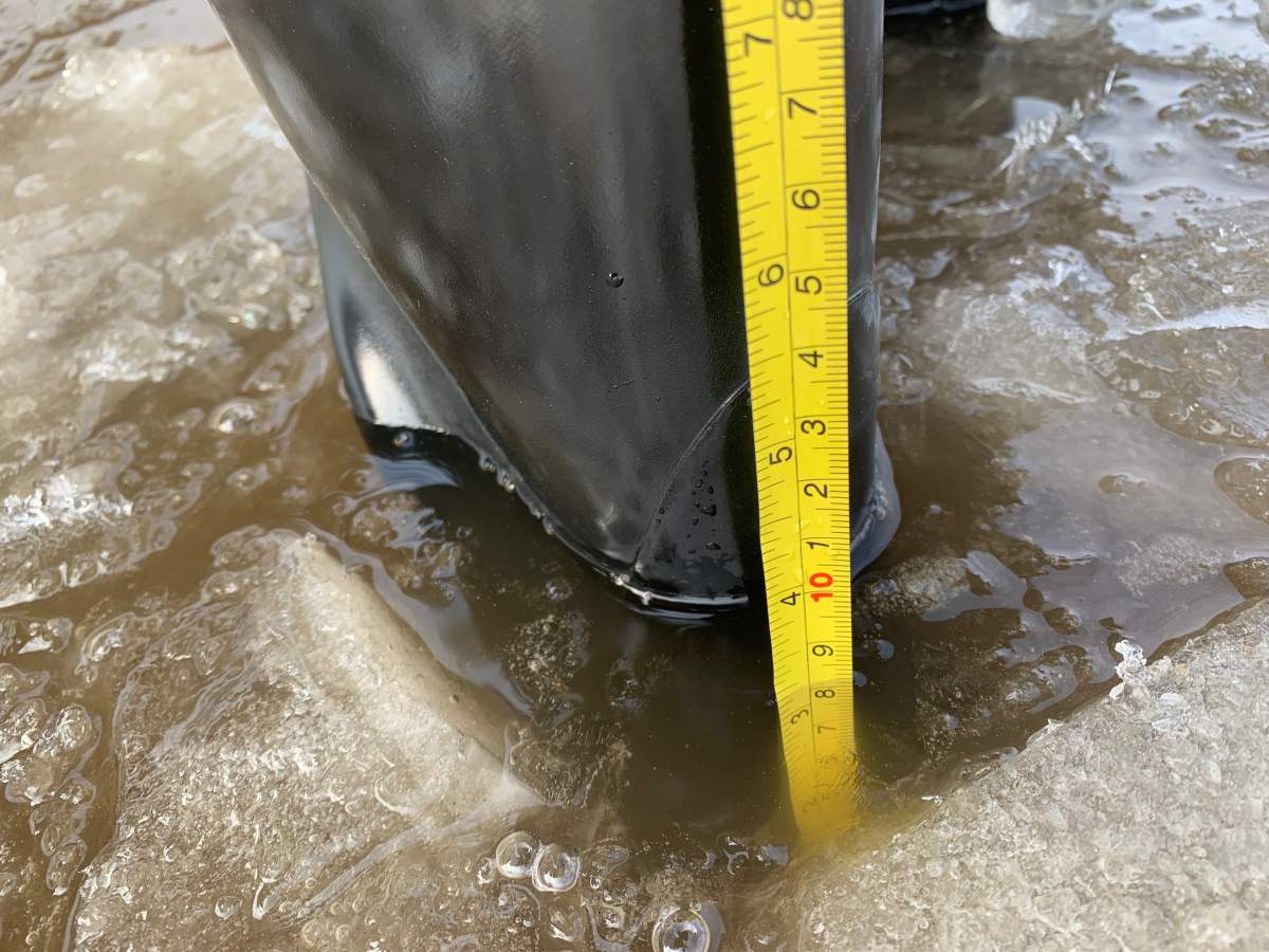 A St. James resident measuring the flood water in their back alley.
