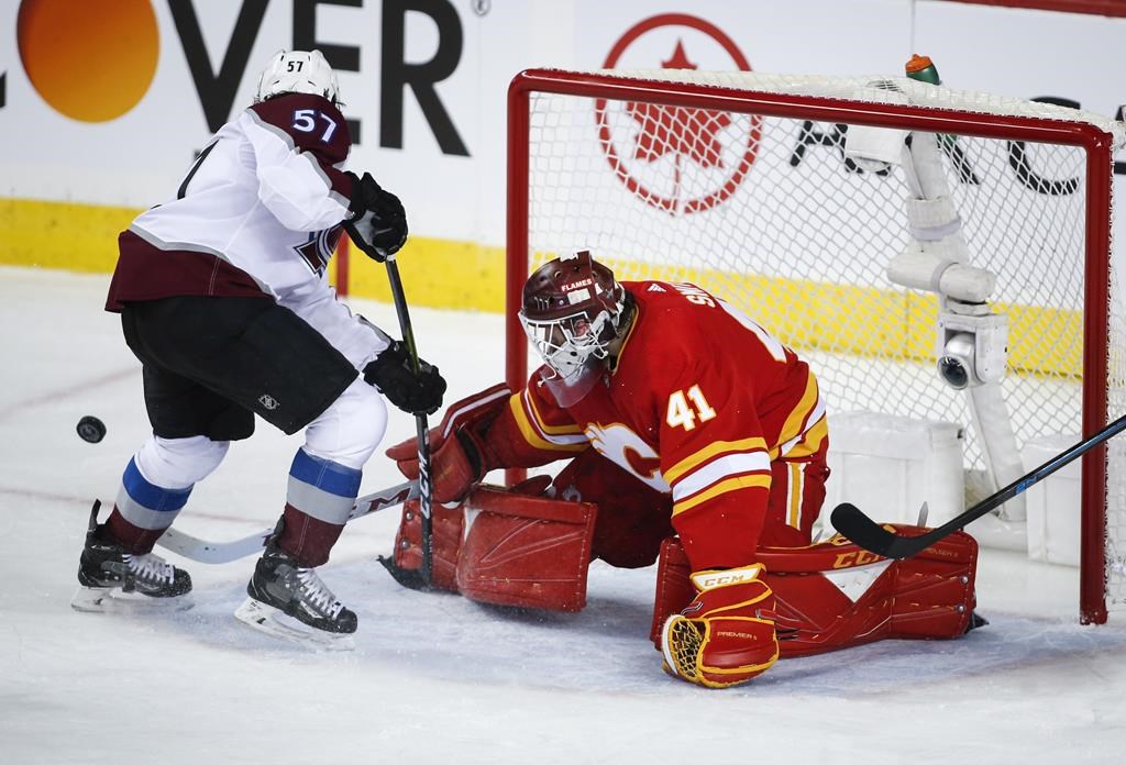 Colorado Avalanche's Gabriel Bourque, left, has his shot deflected by Calgary Flames goalie Mike Smith during first period NHL playoff action in Calgary, Thursday, April 11, 2019.THE CANADIAN PRESS/Jeff McIntosh.