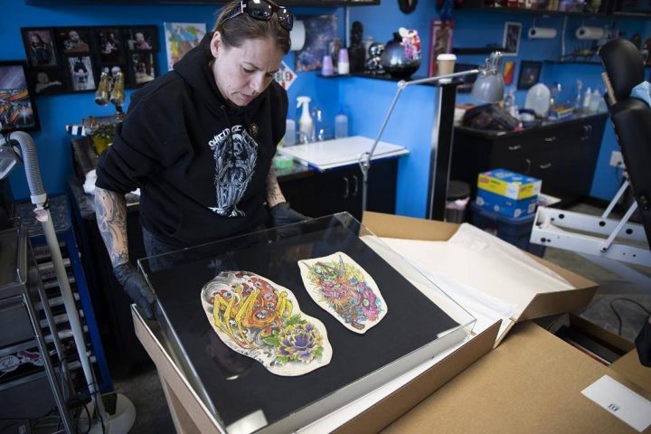 Cheryl Wenzel unboxes her late husband Chris Wenzel's preserved skin which displays his back, arm and thigh tattoos at Electric Underground Tattoos in Saskatoon.
