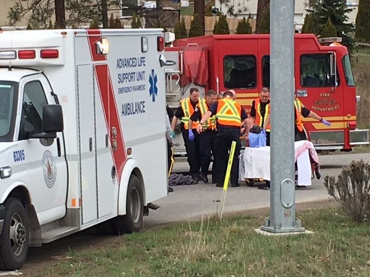 Emergency crews attend to an injured man at Glenmore Road and John Hindle Drive in Kelowna on Saturday morning.
