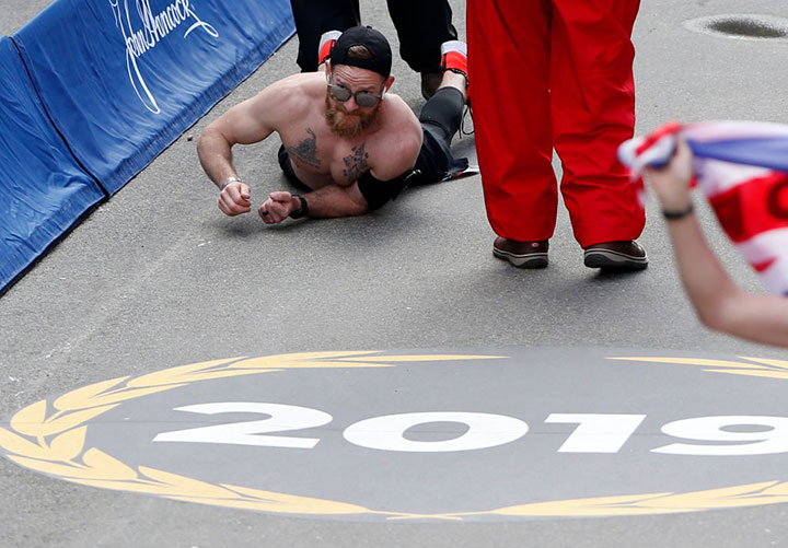 Micah Herndon, a former Marine from Ohio, crawls down Boylston Street towards the finish line of the 123rd Boston Marathon on April 15, 2019.
