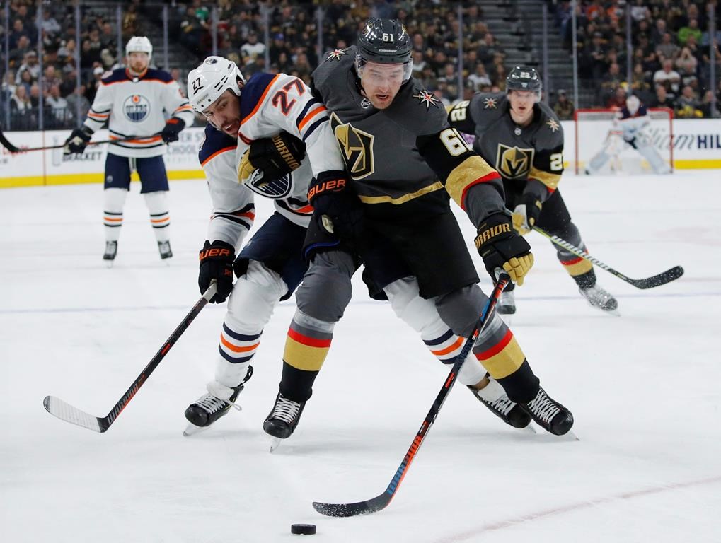 Edmonton Oilers left wing Milan Lucic (27) and Vegas Golden Knights right wing Mark Stone (61) vie for the puck during the first period of an NHL hockey game Monday, April 1, 2019, in Las Vegas.
