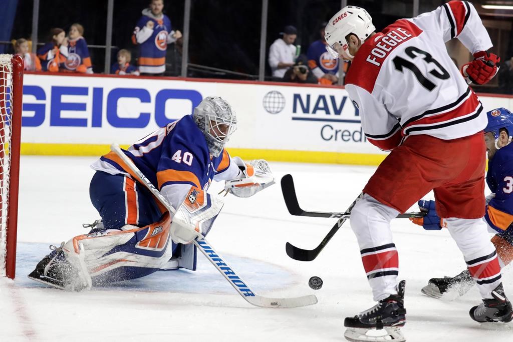 Carolina Hurricanes left wing Warren Foegele (13) attacks New York Islanders goaltender Robin Lehner (40), of Sweden, during the first period of Game 2 of an NHL hockey second-round playoff series, Sunday, April 28, 2019, in New York. (AP Photo/Julio Cortez).