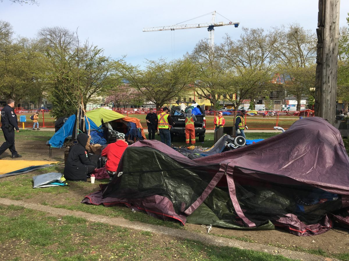 Vancouver police and park board staff work to dismantle tents in the infield of Oppenheimer Park, where homeless campers have been living since last year. The infield has been cleared for field maintenance work, which could take at least six weeks.