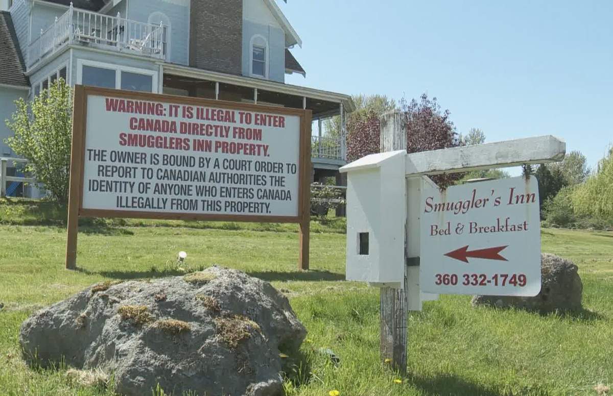 A sign warning people not to cross the border into Canada is posted outside the Smugglers Inn bed and breakfast in Blaine, Wash. The sign is one of the bail conditions imposed on owner Robert Boulé, who has been charged with helping migrants enter Canada from the U.S.
