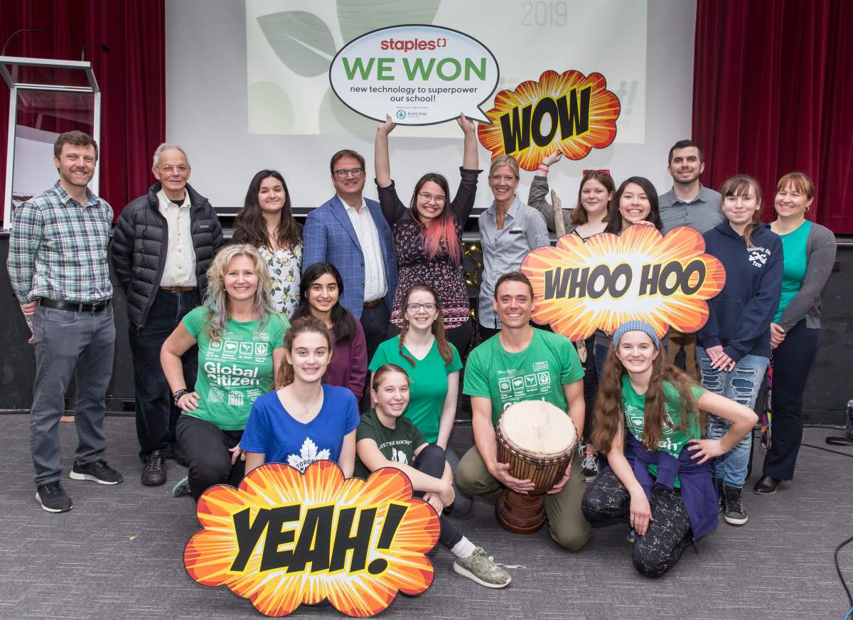 Staples Canada CEO David Boone and Cathy Jeffries, General Manager of a Staples store in Waterloo pose with student and staff members of Eastwood Collegiate’s IMPACT environmental club after an assembly on Wednesday.
