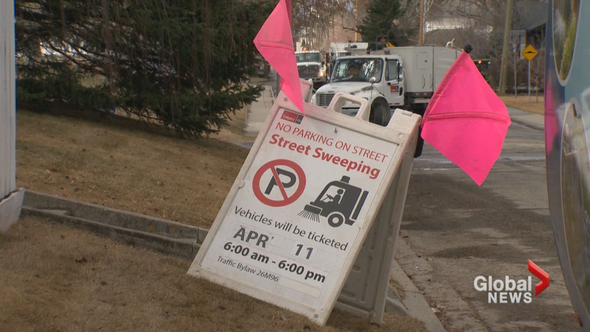 A street sweeping sign is seen on a Calgary street. 