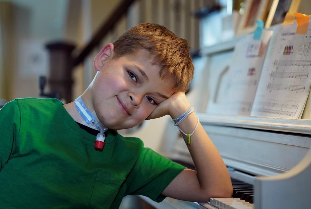 Braden Scott smiles after practicing on the piano in Tomball, Texas on Friday, March 29, 2019. Braden was diagnosed with the mysterious syndrome called acute flaccid myelitis, or AFM, in 2016 and was paralyzed almost completely. But since then he has recovered much of his muscle function. His parents believe a lot of it has to do with thousands of hours of physical therapy. (AP Photo/David J. Phillip)