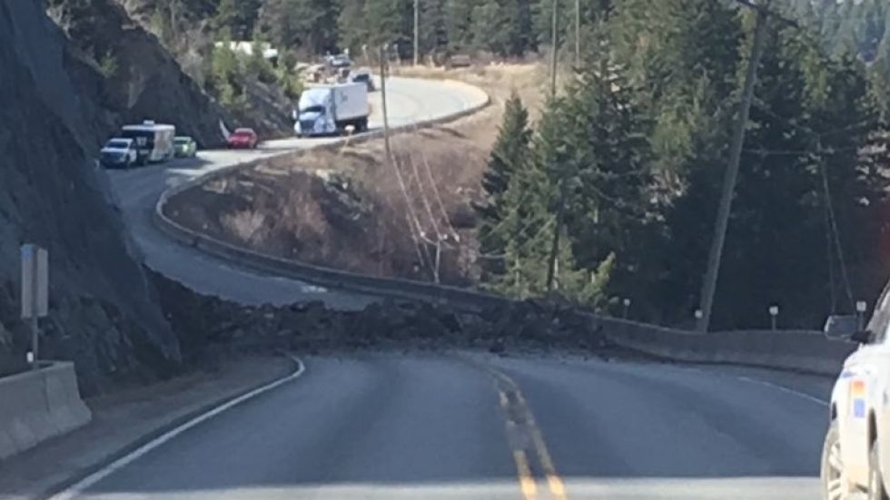A photo from the scene shows rocks covering both lanes of the highway.