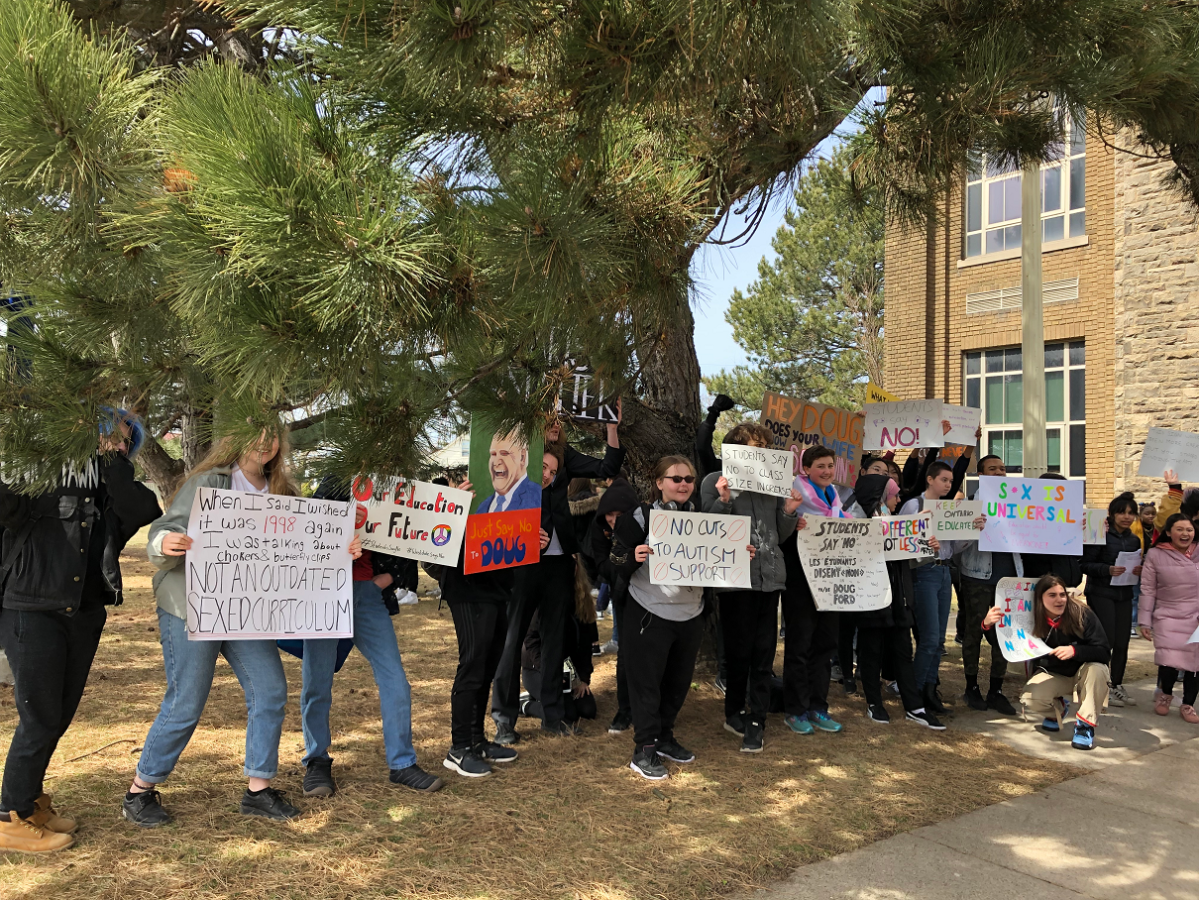 Students posing with signs at the walkout on Thursday afternoon.