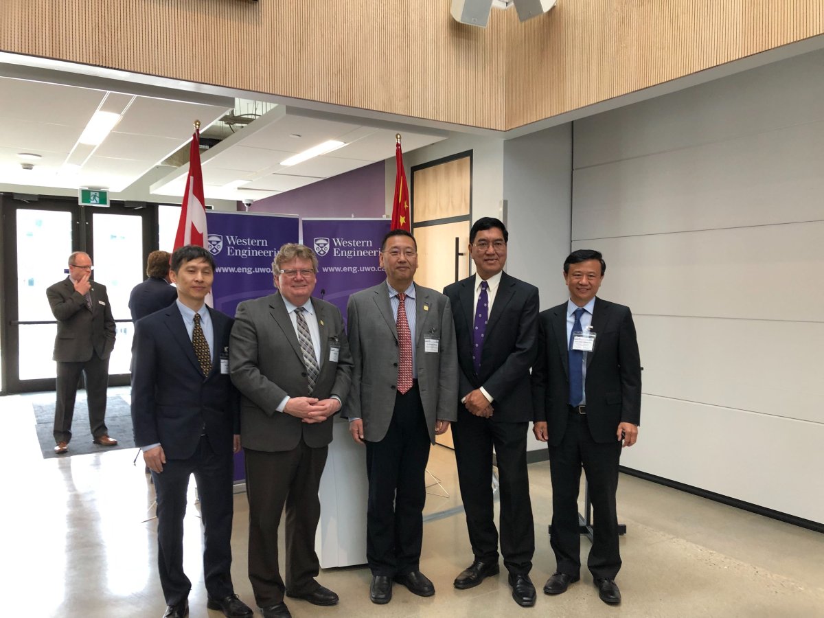 Mayor Ed Holder (second from left) and Western University President Amit Chakma stand with officials from the China Automotive Battery Research Institute Co. Ltd.