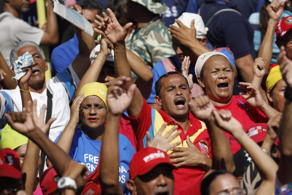 Militia members and supporters of Venezuela's President Nicolas Maduro sing an anthem to late former President Hugo Chavez, outside Miraflores presidential palace in Caracas, Venezuela, Monday, May 20, 2109.