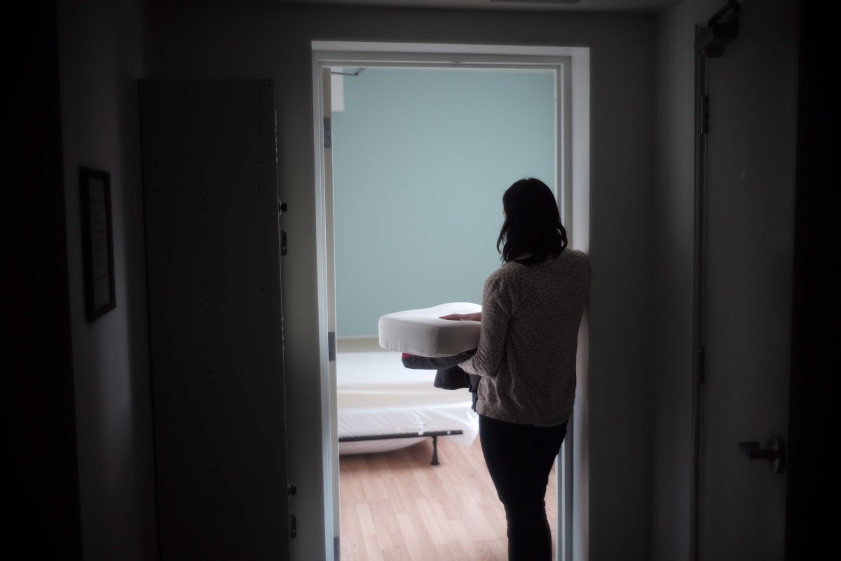 A staff member carries bedding in one of the suites at Toronto's Interval House, an emergency shelter for women in abusive situations, in a Feb. 6, 2017, file photo.