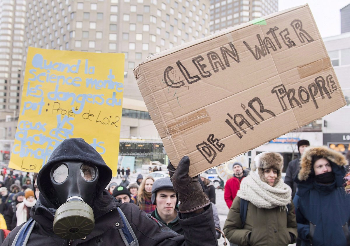 People hold up signs demanding action on climate change during a demonstration in Montreal, Saturday, December 8, 2018. 
