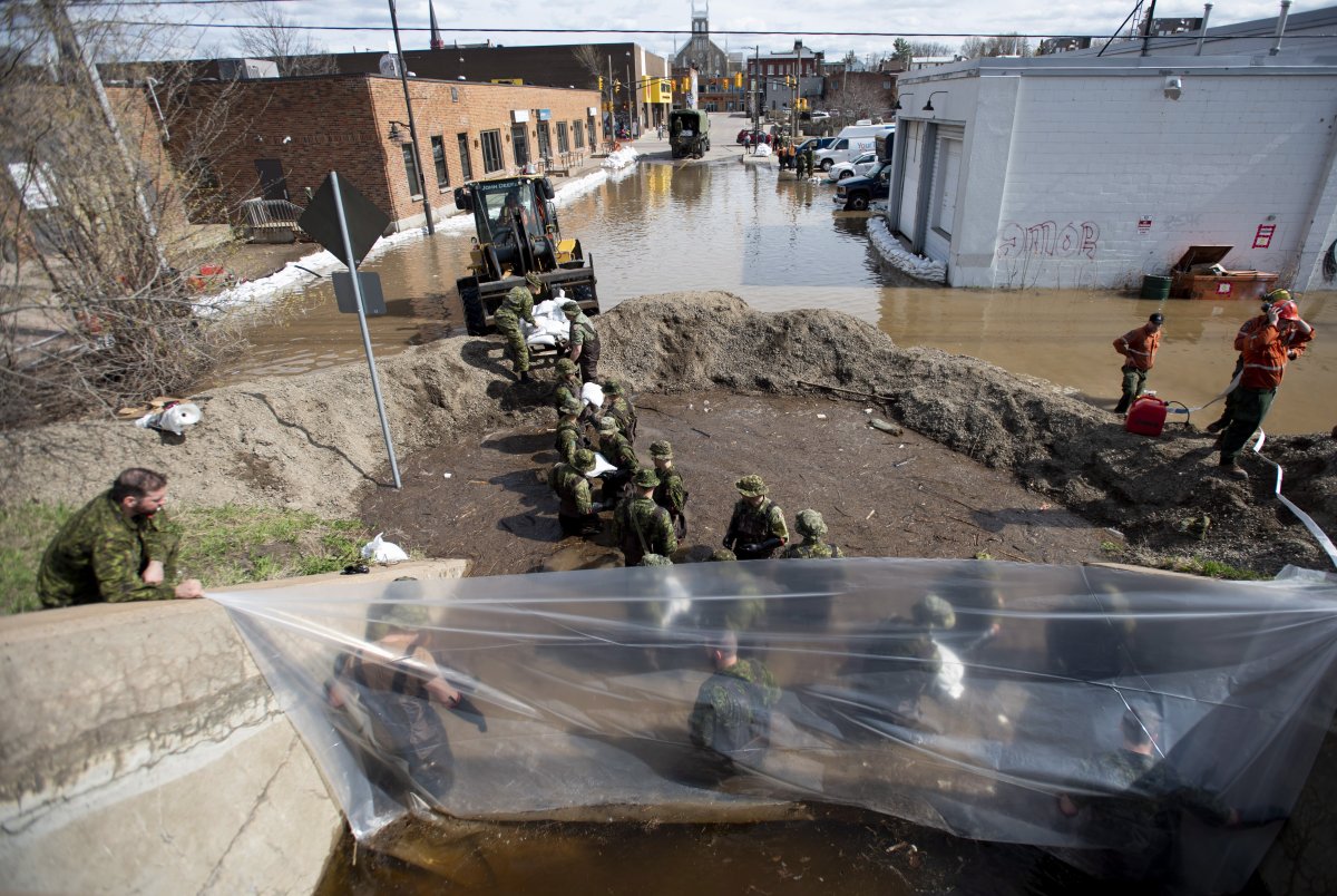 Canadian Forces members build a wall of sandbags at the underpass on Alexander Street to try to keep back floodwaters in Pembroke, Ont., Saturday, May 11, 2019. 