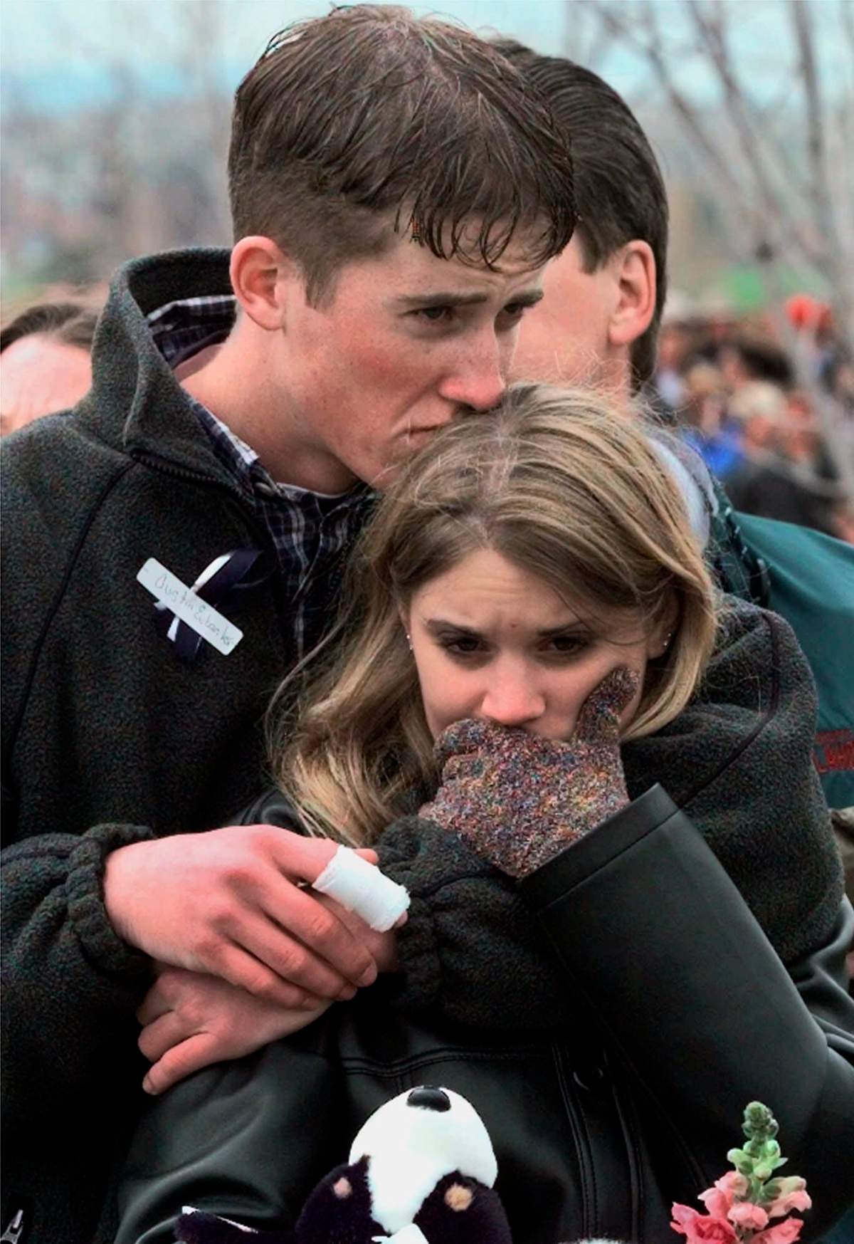 FILE - In this April 25, 1999 file photo, shooting victim Austin Eubanks hugs his girlfriend during a community wide memorial service in Littleton, Colo., for the victims of the shooting rampage at Columbine High School the previous week.