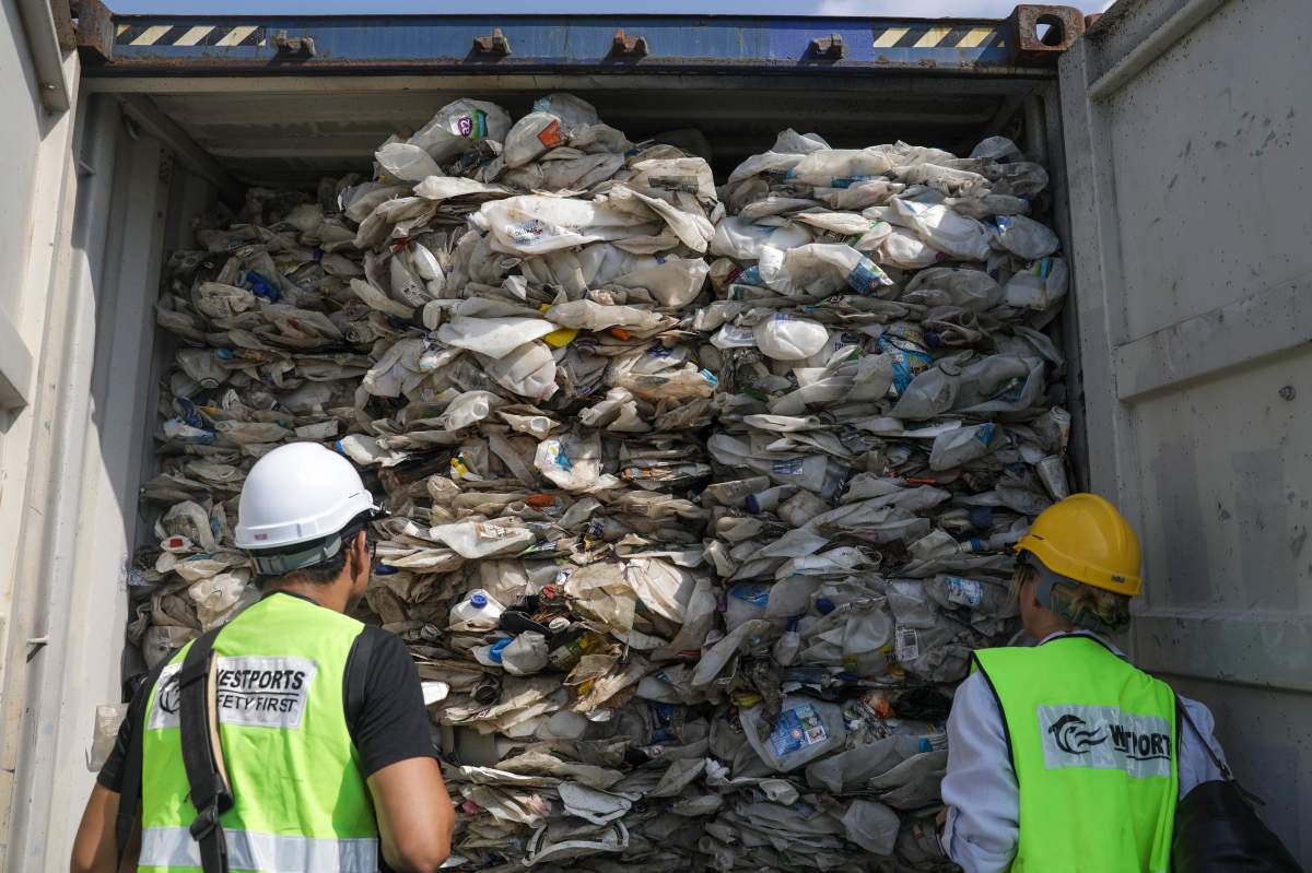 Members of the media look at plastic waste inside cargo containers before it is sent back to the country of origin in Port Klang, Selangor, Malaysia, 28 May 2019.