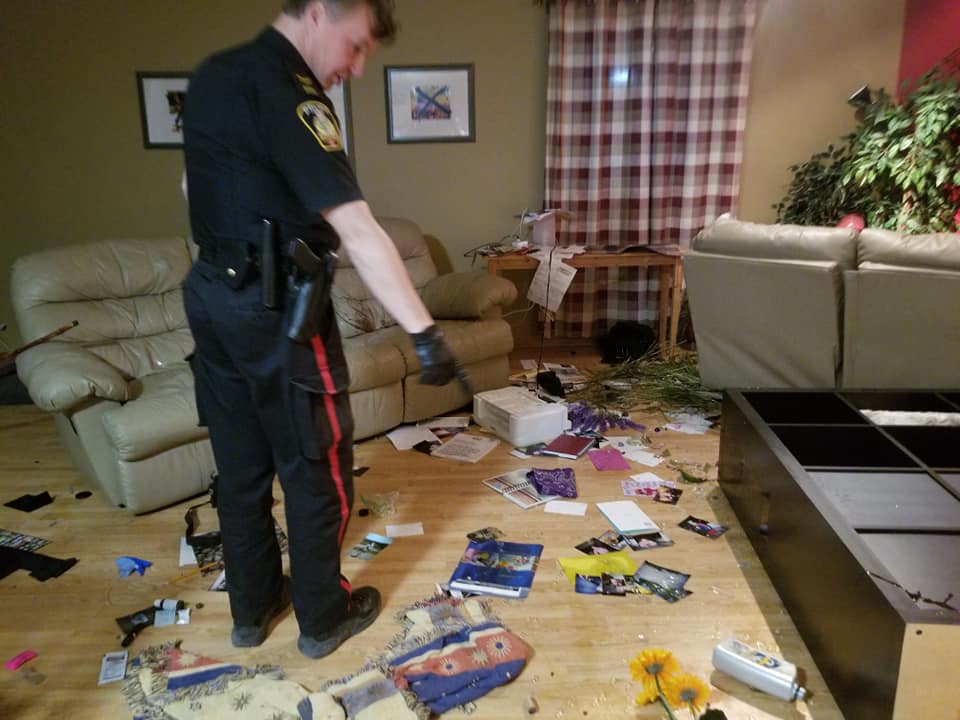 An officer points to damage in the home.