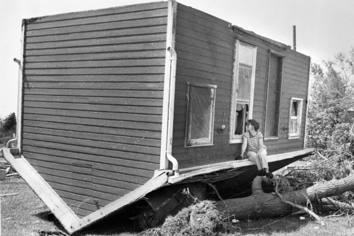 Betty Walsh peers through a broken window into a neighbours cabin on June 3 1985, during a cleanup operation in Barrie, Ont. 